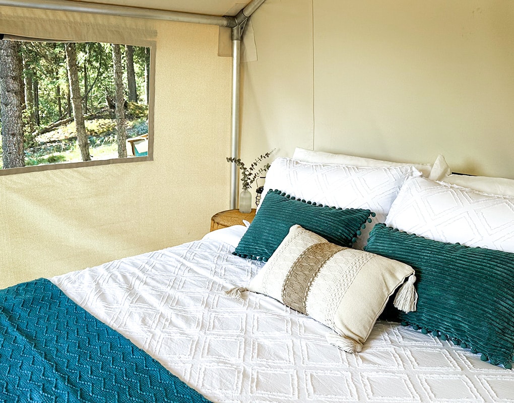 a bed with pillows and a window