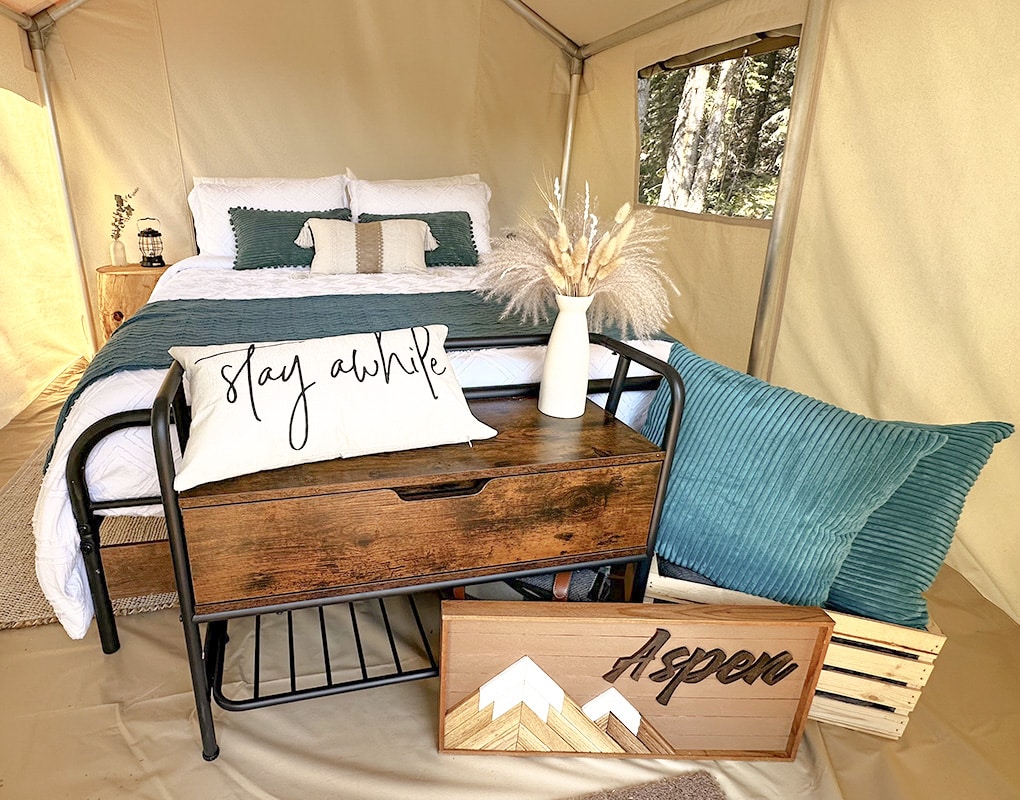 a bed with a wood table and a vase of flowers