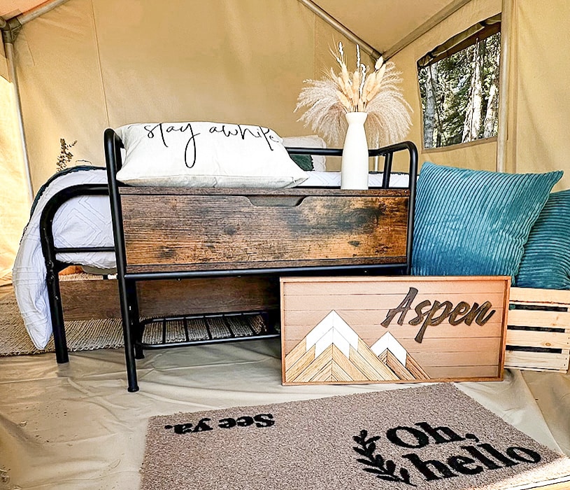 a bed with pillows and a sign in a tent