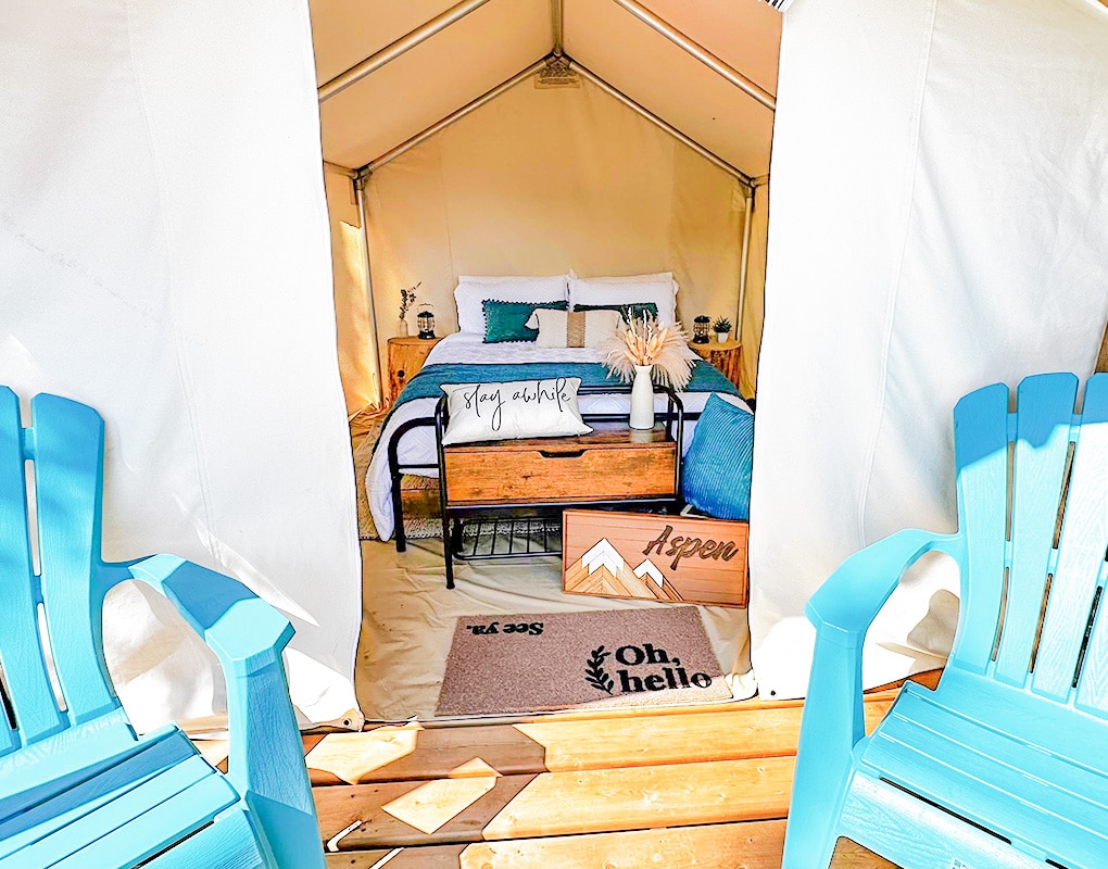 a bed and chairs in a tent