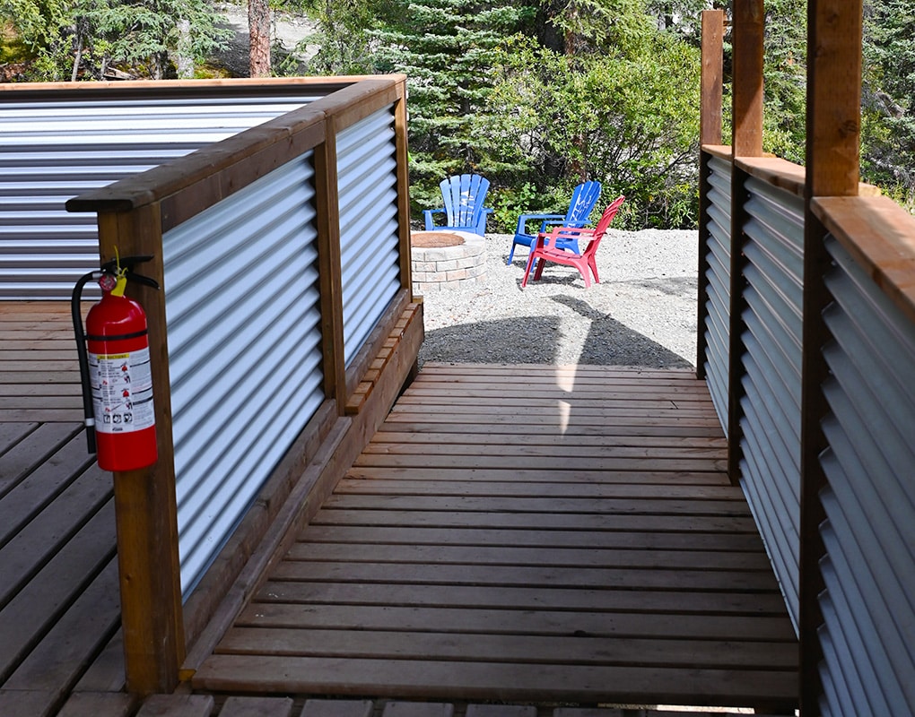 a deck with a fire extinguisher and chairs in the background