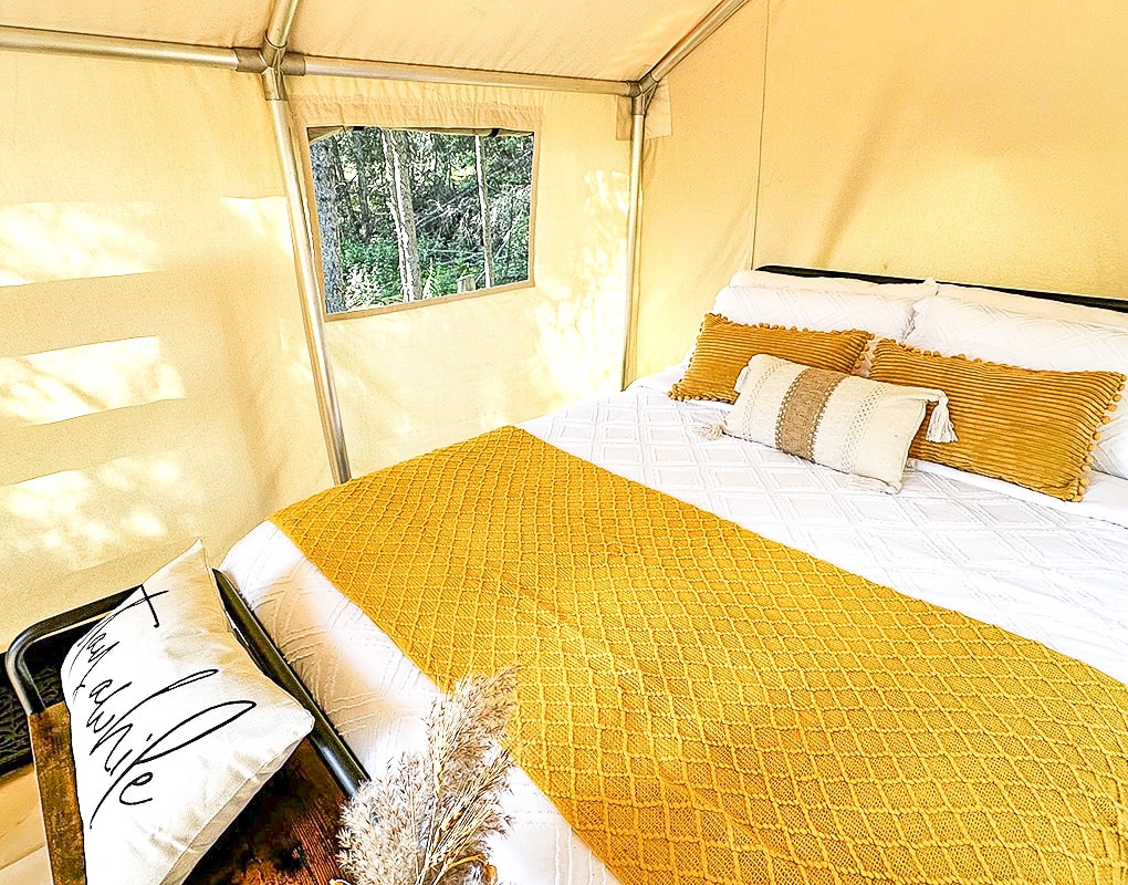 a bed with pillows and a window
