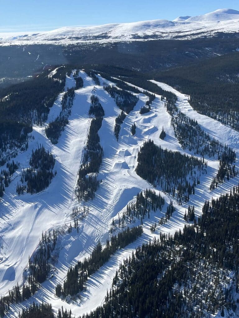 a ski slope with snow and trees